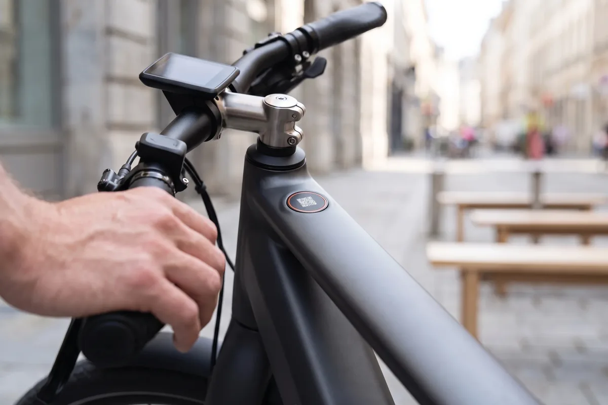 Ein rundes QR-Inlay mit orangem Rand, bündig im Rahmen eines grafitgrauen E-Bikes