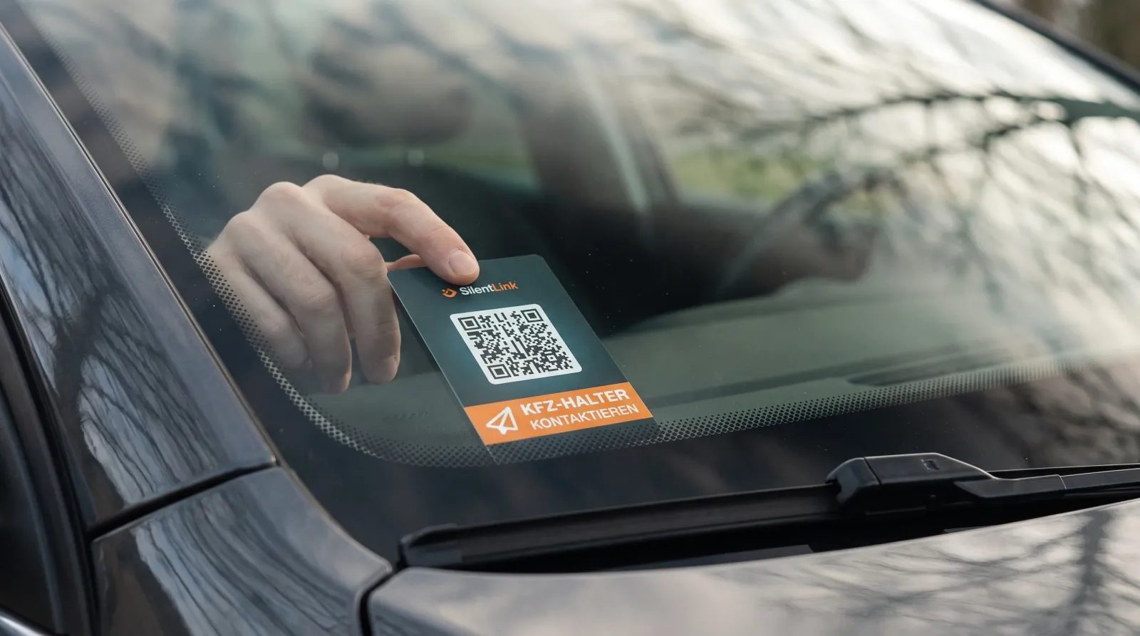 Die DriveID wird von innen an die untere Ecke der Windschutzscheibe gedrückt, von außen durch das Glas gesehen