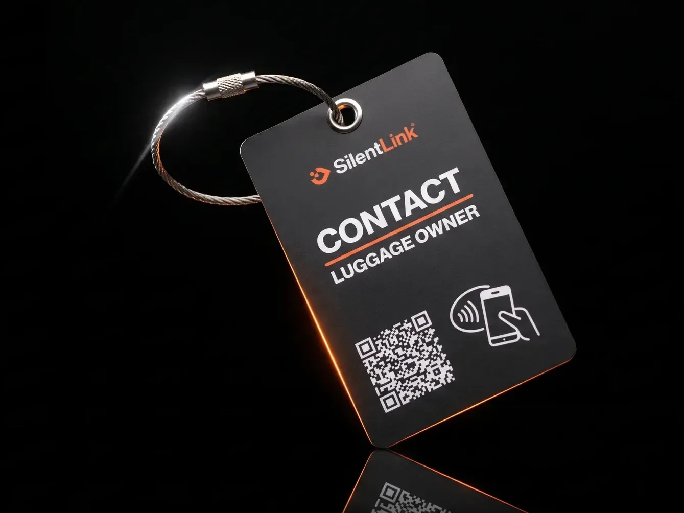 Die TravelID an ihrer Stahlschlaufe auf dunklem Grund: SilentLink-Logo, der Aufdruck Contact Luggage Owner, QR-Code und NFC-Symbol